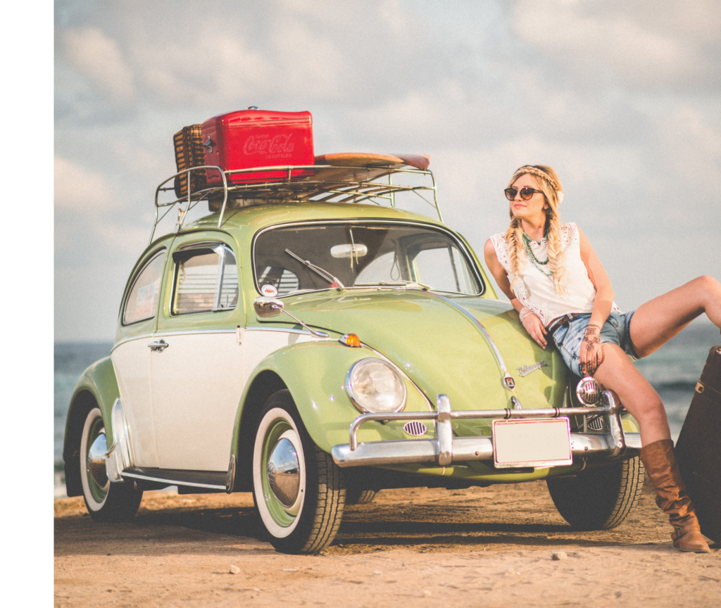 fiatal hölgy mosolyog egy autónak dőlve, mert CASCO és egyéb biztosításai rendben vannak.